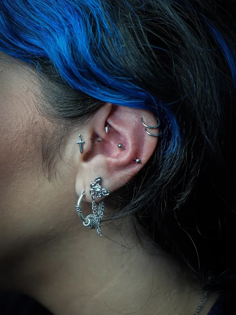 Curated ear stack with helix and conch — piercing by Foenix Ink, Hollywood FL, implant-grade titanium (1/3)